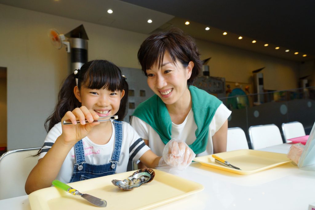 真珠を取り出す体験をする親子／九十九島パールシーリゾート（長崎県佐世保市）