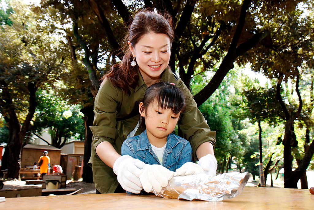さつまいもをアルミホイルで包む親子／羽根木プレーパーク（東京都/世田谷区）