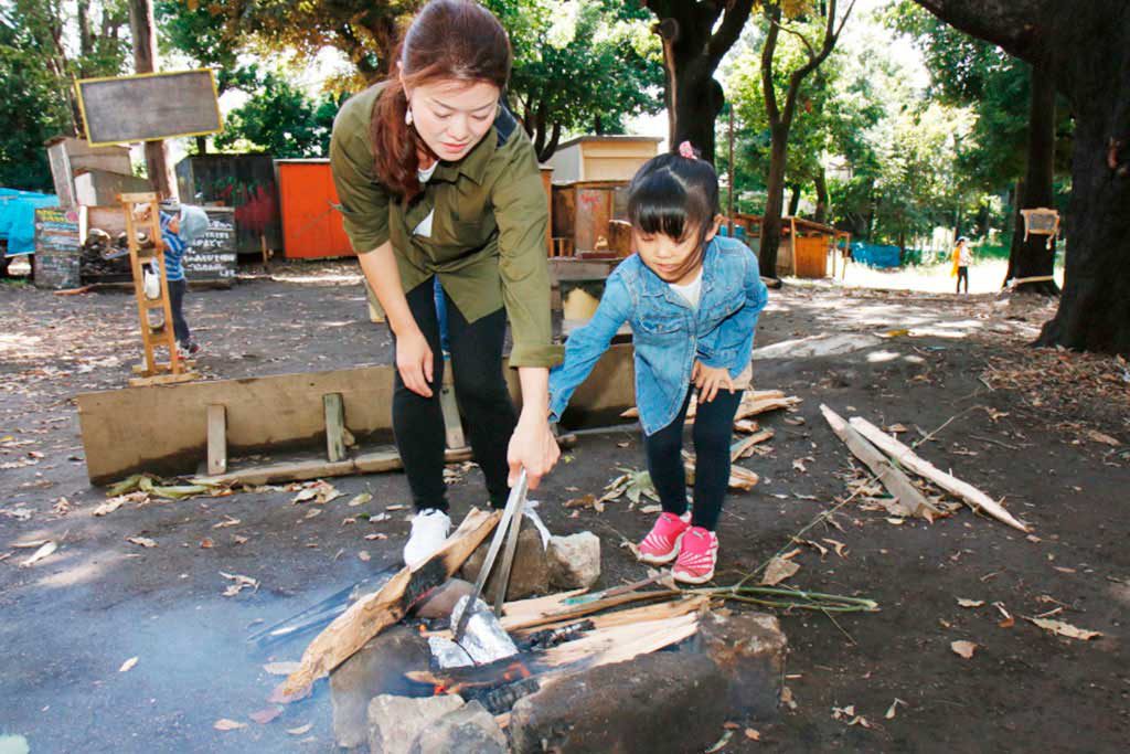 たき火の中にさつまいもを投入／羽根木プレーパーク（東京都/世田谷区）