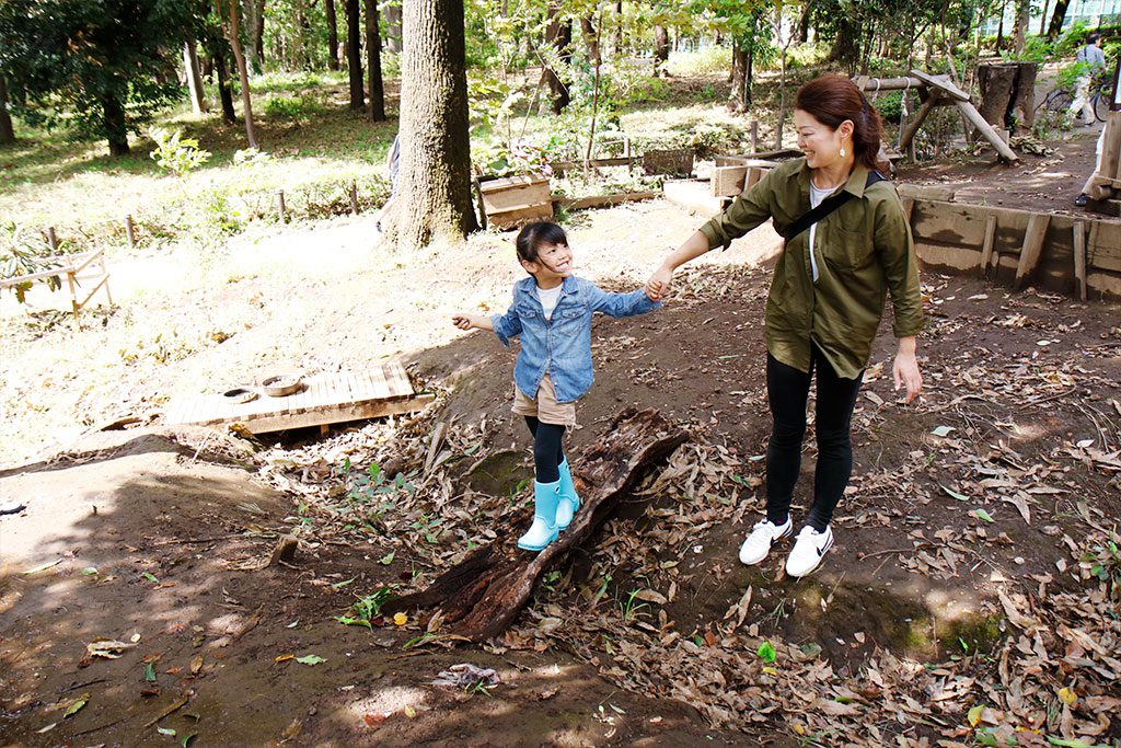 でこぼこ道を手を繋いで歩く親子／羽根木プレーパーク（東京都/世田谷区）