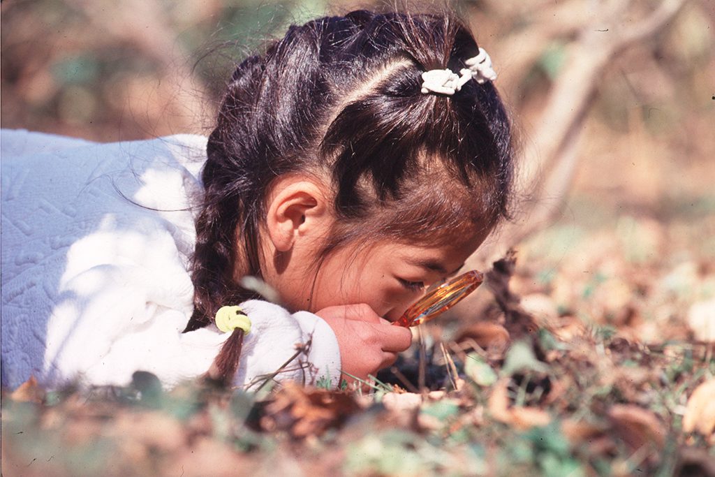 虫メガネでのぞき込む子ども