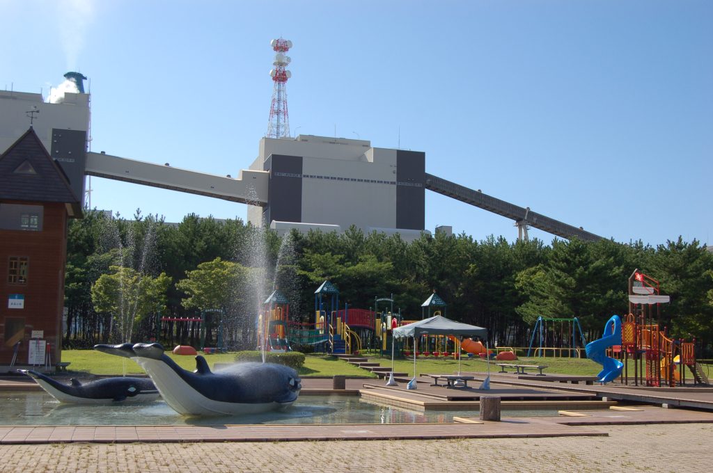 冒険広場のじゃぶじゃぶ池と遊具、背景には能代火力発電所/能代エナジアムパーク(秋田県/能代市)
