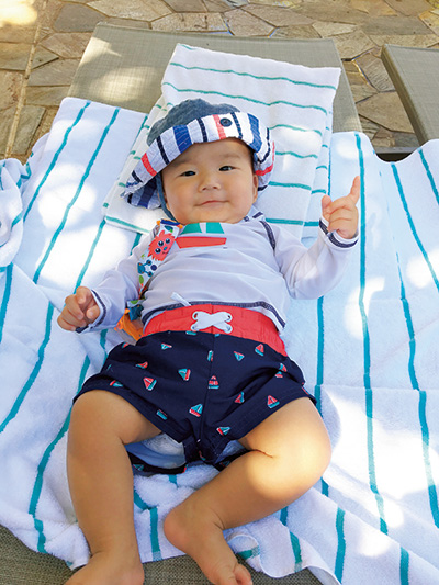 ビーチの砂浜で寝転がる赤ちゃん（ハワイ）