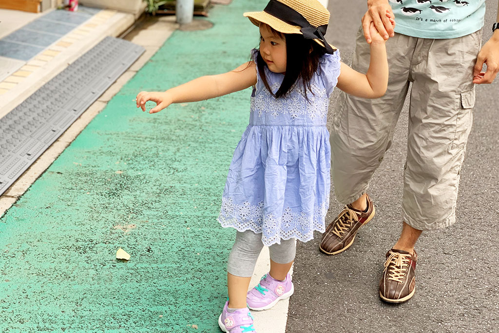 おさんぽでお花を見つけて指さす女の子