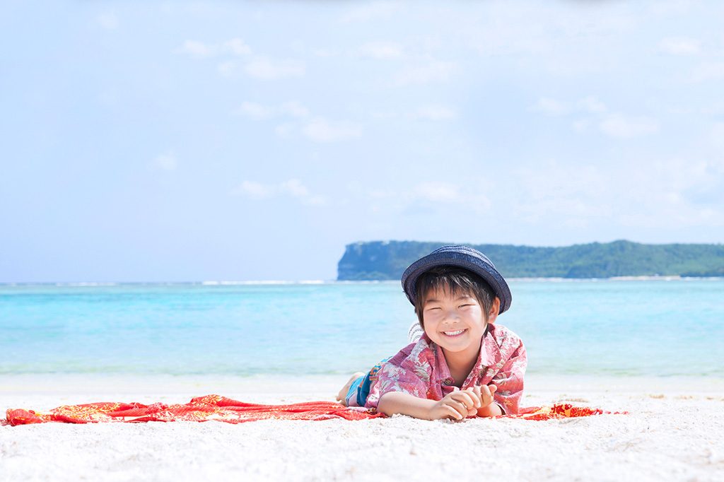 イメージ：ビーチで寝転ぶ子ども（グアム）