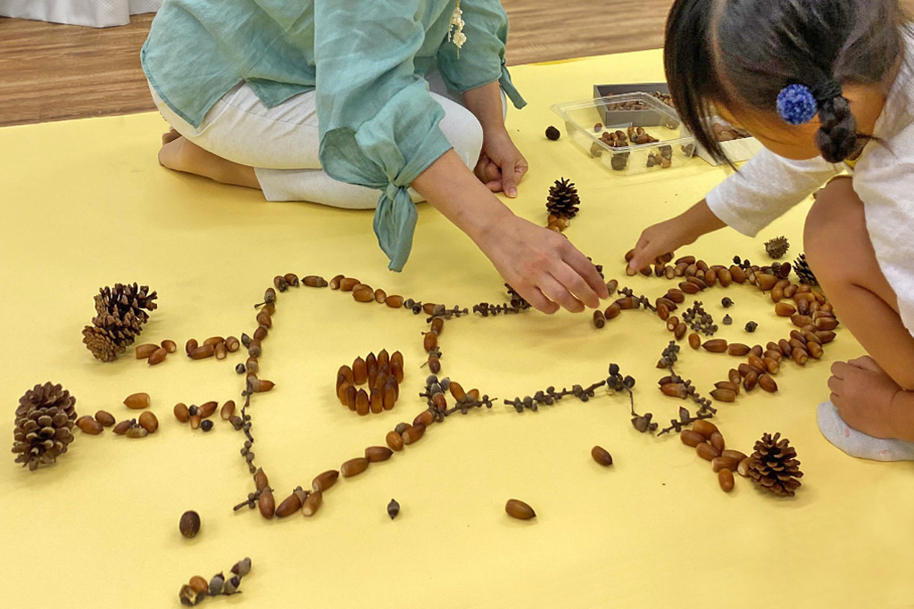 どんぐりを並べて絵を描く様子
