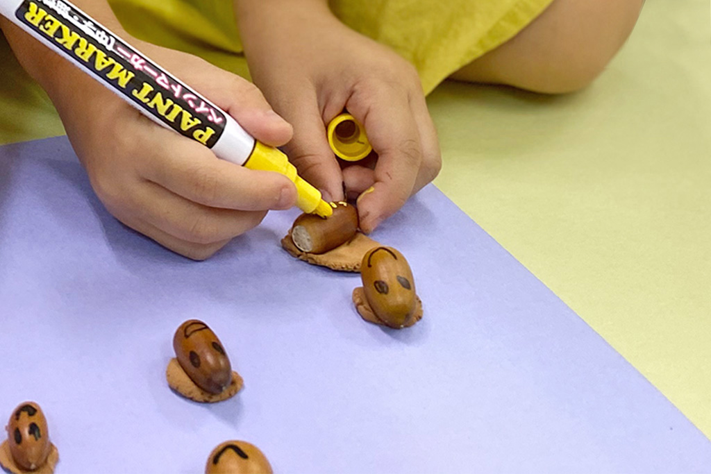 どんぐりに顔を描く様子