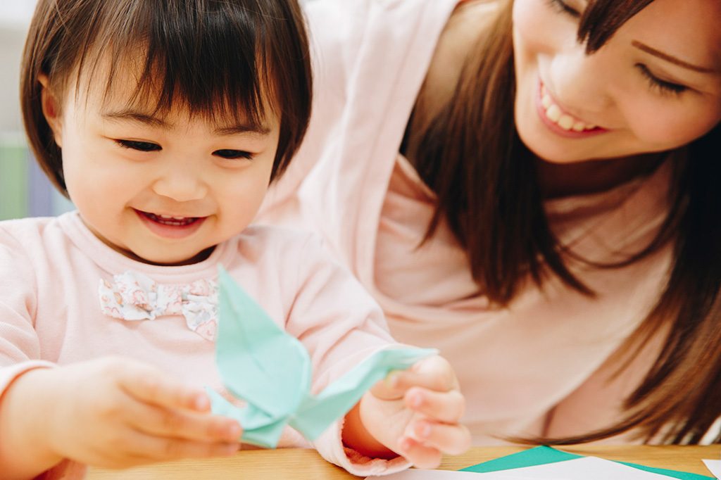 折り紙で遊ぶ子ども