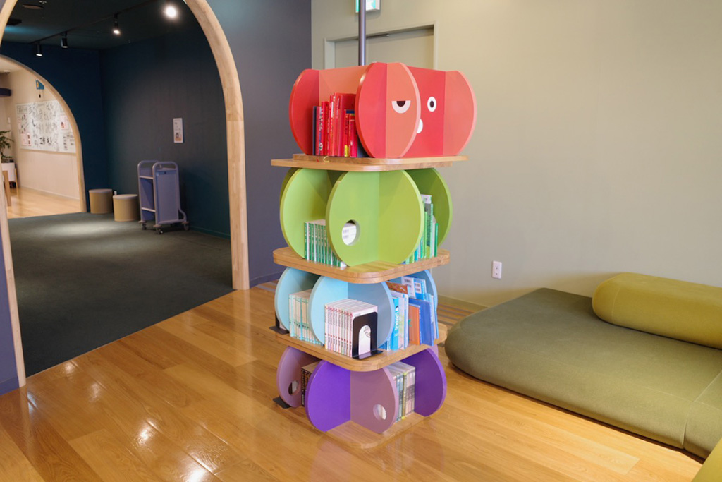 背表紙の色別に並べられた本棚/絵と言葉のライブラリー ミッカ(東京都/葛飾区)