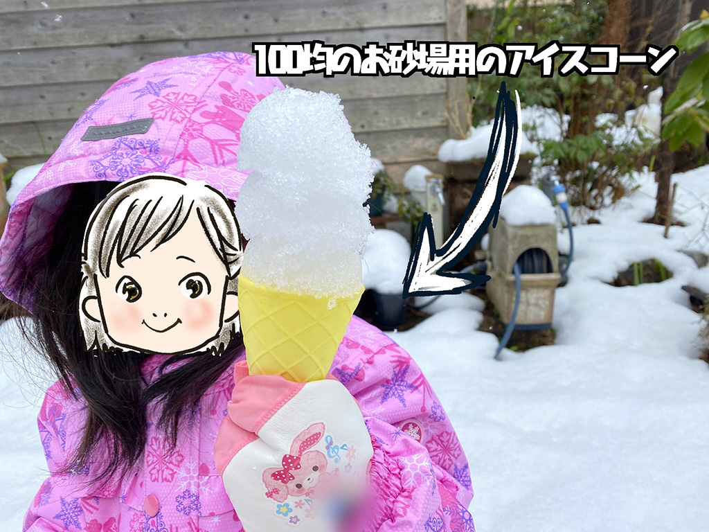 砂場用のアイスコーンに雪を乗せて遊ぶ子ども