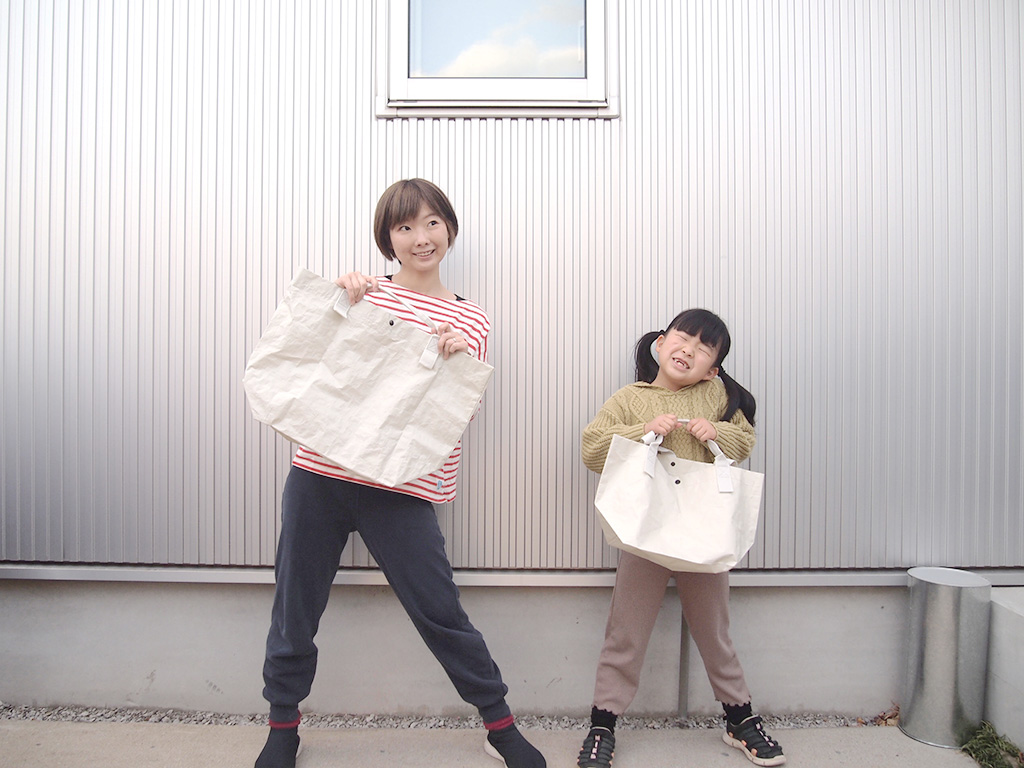 無印良品のポリエチレン・トートバッグを持つ様子