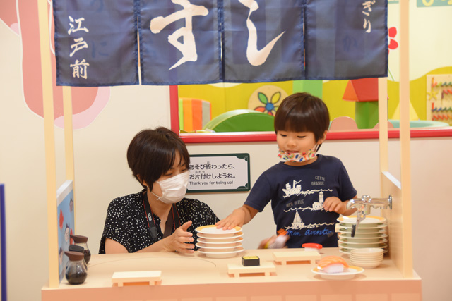 街のエリア「カラフルタウン」のおすし屋さんで遊ぶ親子/東京ドームシティ「アソボ~ノ!」(東京都/文京区)