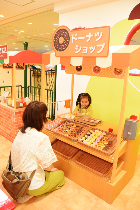 街のエリア「カラフルタウン」のドーナツショップで遊ぶ親子/東京ドームシティ「アソボ~ノ!」(東京都/文京区)