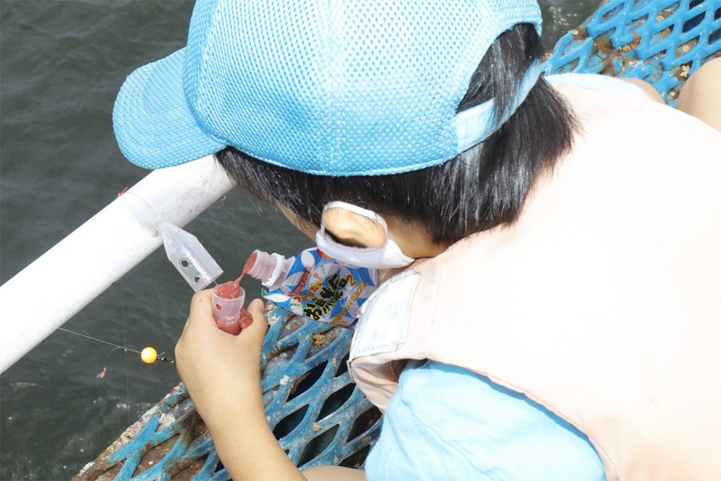 仕掛けについている容器にエサを入れる様子