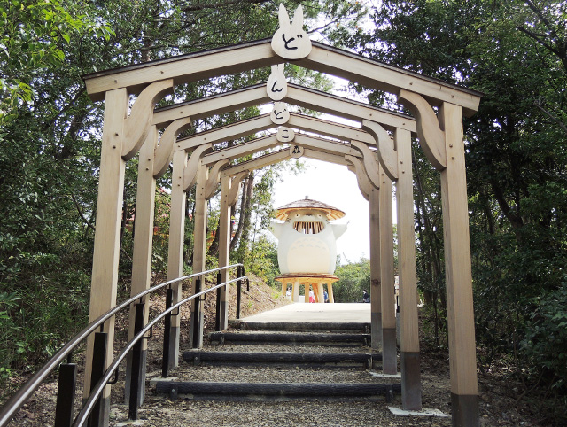 「どんどこ森」と書かれたゲートの向こうに、トトロを模した木製遊具「どんどこ堂」/ジブリパーク（愛知県／長久手市）