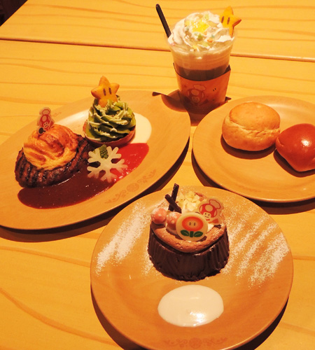 手前のデザートが、シェフ特製の切り株ケーキ ～チョコレート～ 900円。中央の2皿が、シェフ特製グラタン・ハンバーグステーキ＆マッシュポテトのツリー（パンまたはライス付き） 2600円／ユニバーサル・スタジオ・ジャパン（大阪府）