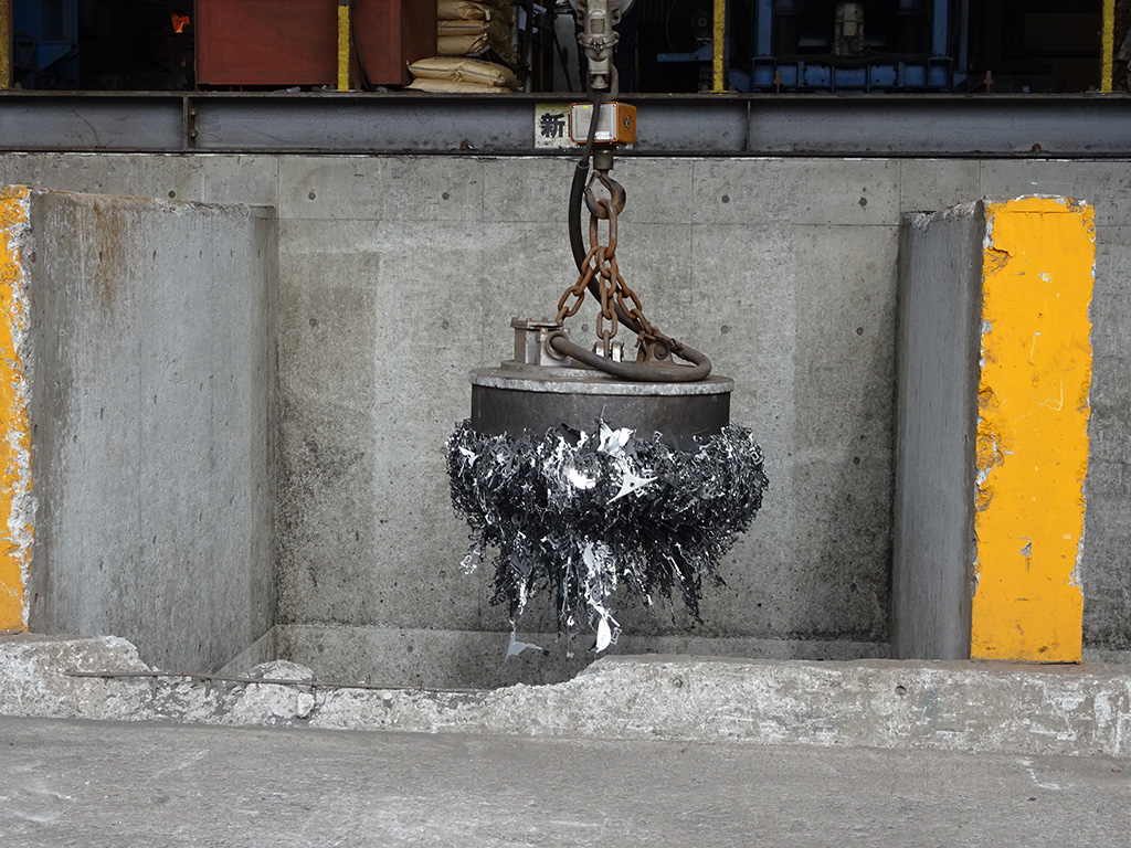 フライパンを作る工程：磁石で吊り上げられた鉄くず/おもいのフライパンBASE（愛知県/碧南市）