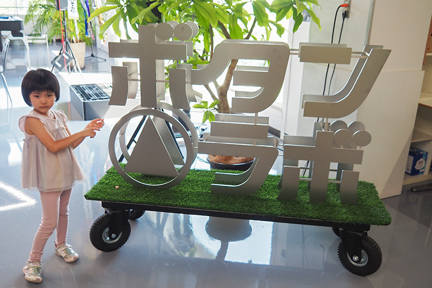 ボタンラボのロゴ看板と子どもを記念撮影/OSEBA（東京都八王子市）