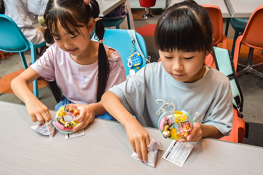 チップとデールのスナックケースにグミを入れる子どもたち
