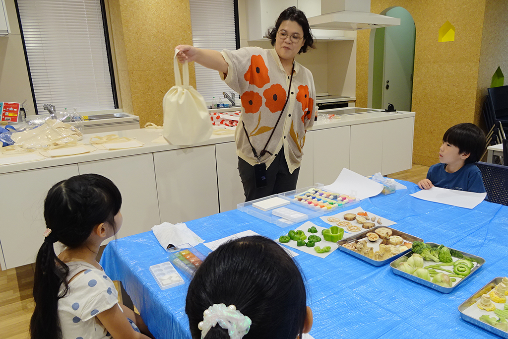 オリジナルサコッシュの作り方の説明を聞く様子/るるぶKids ピーマンの料理体験イベント