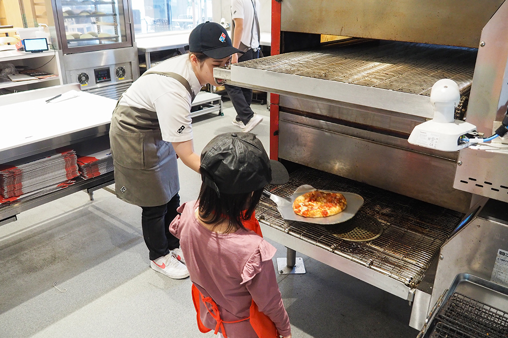 オーブンから出てきたピザは熱いので、ドミノクルーが取り出してくれる/ピザアカデミー