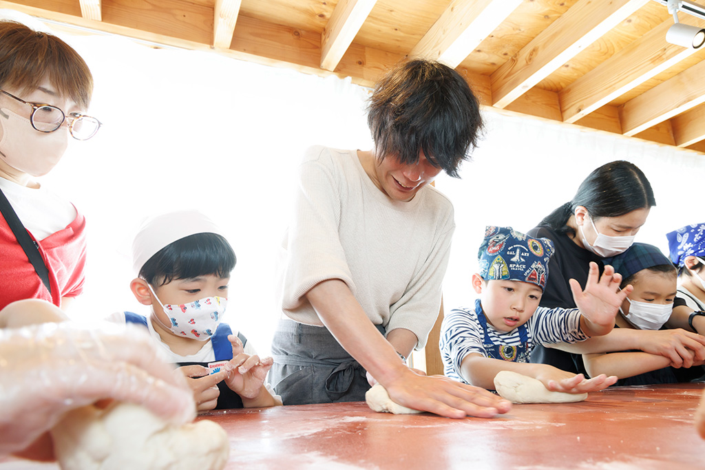 打ち粉(分量外)を敷いた台の上でこねる様子/ベーグルづくりワークショップ