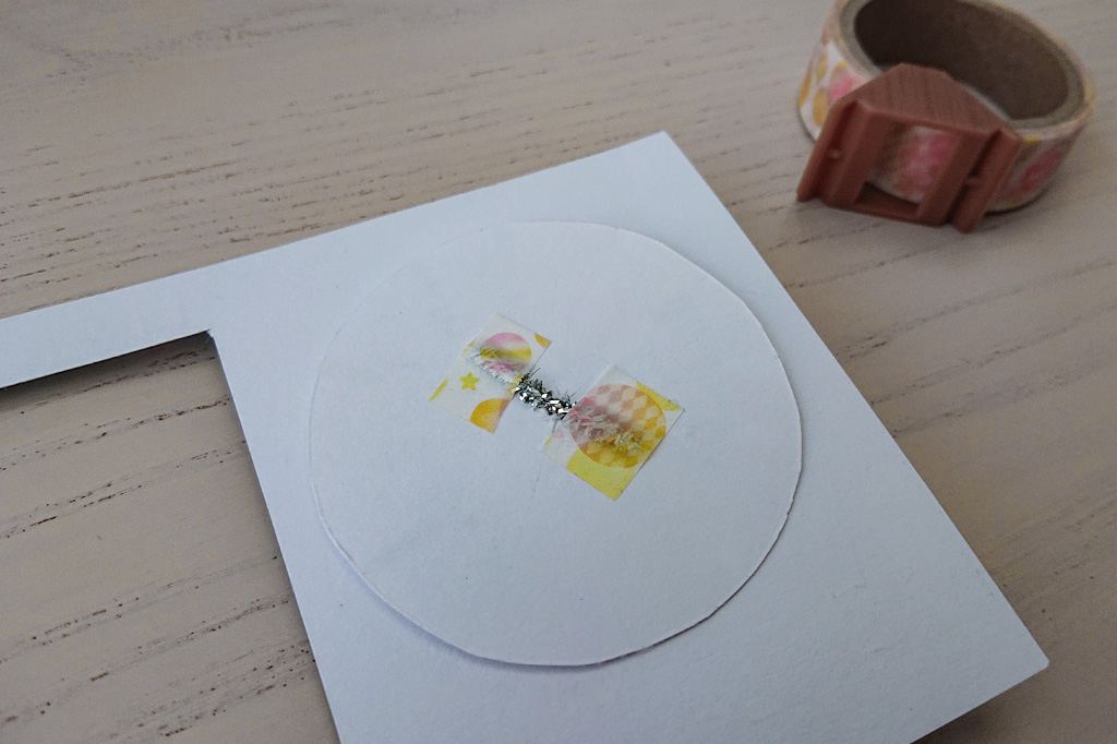 月の円盤の裏に針金をテープで止める／スライド式万年カレンダーの作り方