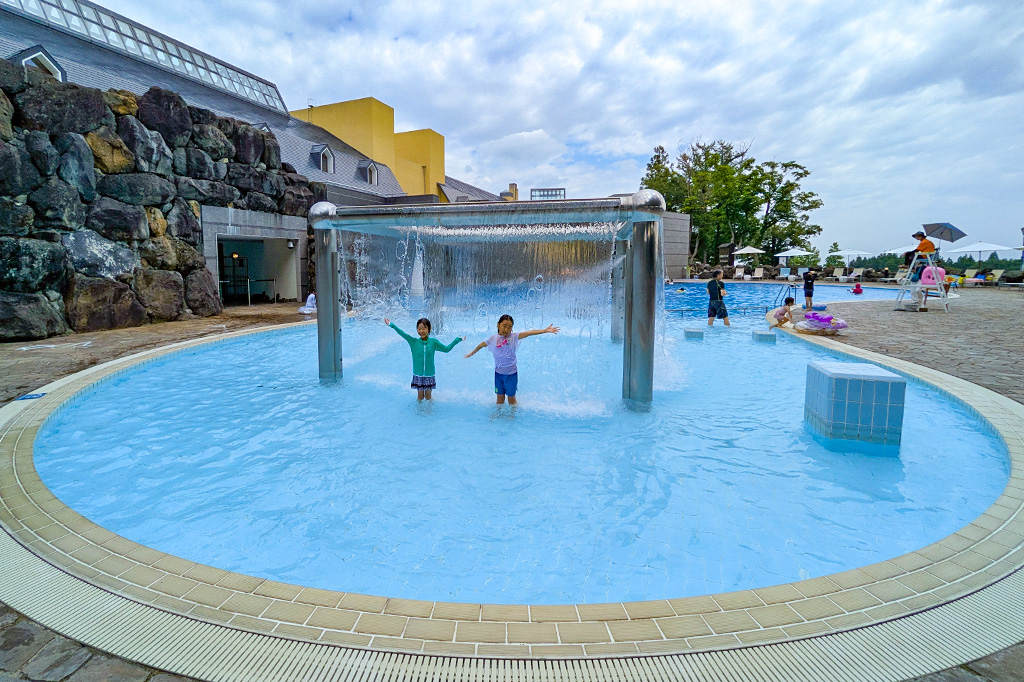 幼児用プールの滝で遊ぶ子どもたち／ロッテアライリゾート（新潟県妙高市）